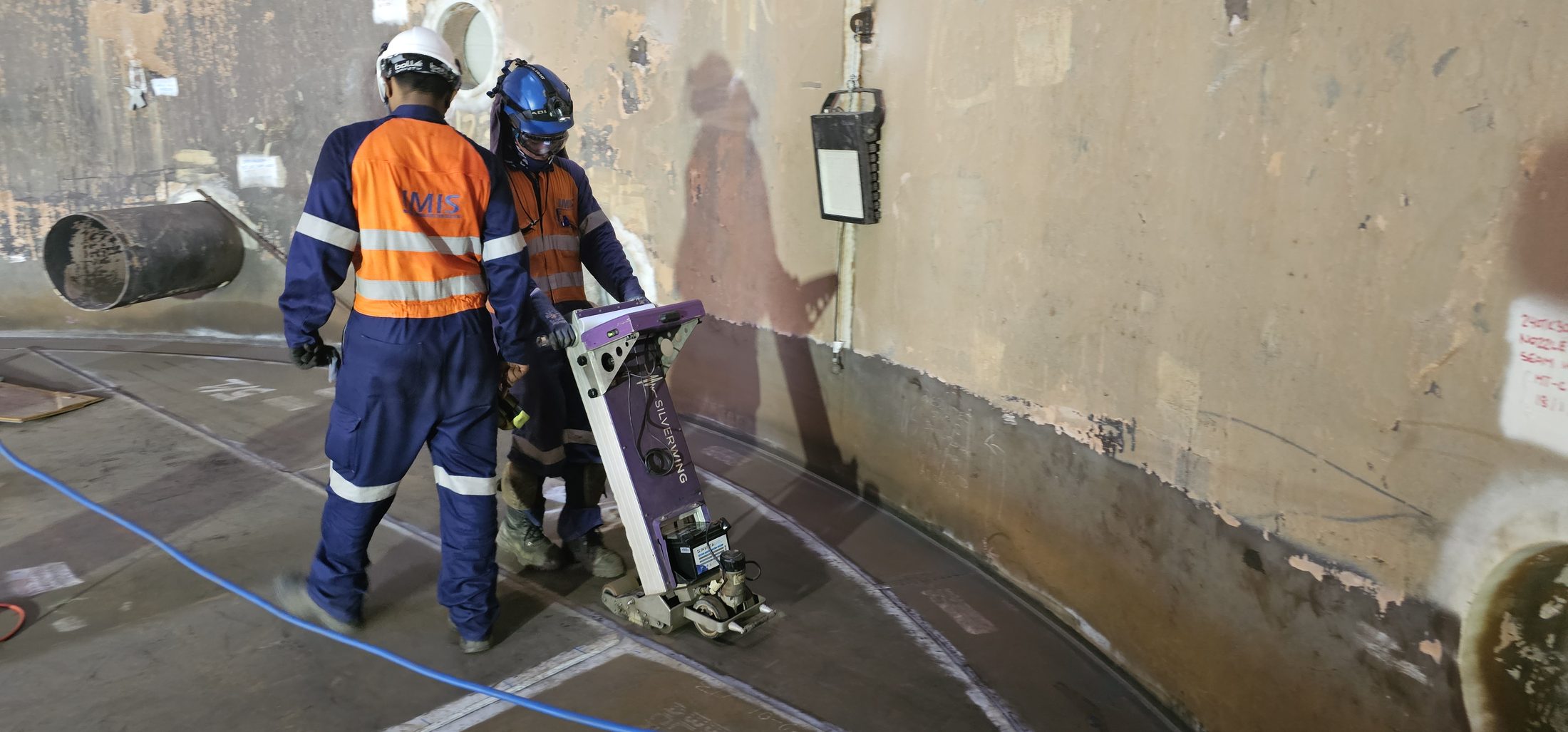 IMIS technicians operating a tank floor magnetic flux leakage scanner